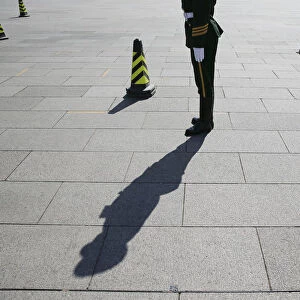 Paramilitary policeman stands guard in front of the Great Hall of the People before