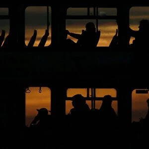 Passengers travel on a bus during sunset in London