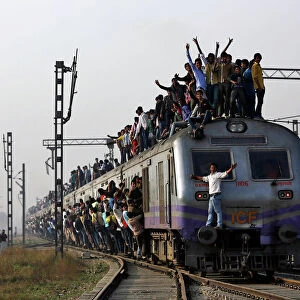 Passengers travel on an overcrowded train on the outskirts of New Delhi