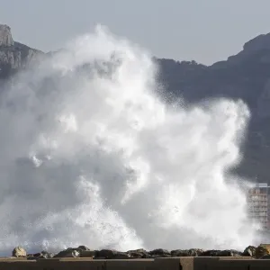 A passer-by walks as a high wave hits the waterfront in Marseille A passer-by walks as a high wave hits the waterfront in Marseille