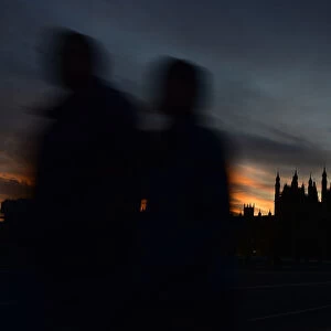 Pedestrians walk over Westminster Bridge with Big Ben and the Houses of Parliament seen behind
