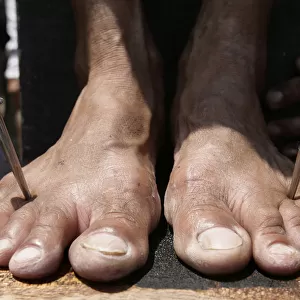 A penitents feet are nailed to a wooden cross on Good Friday in the town of San Juan in
