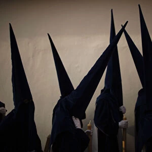 Penitents take part in the procession of Estrella brotherhood during Holy Week in