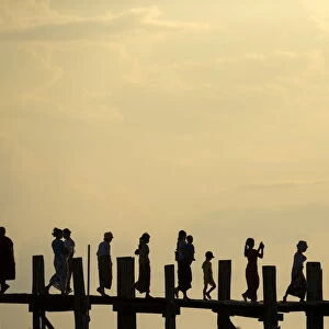 People cross U Bein bridge over Tuangthaman Lake in Mandalay, Myanmar