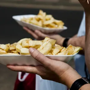 People eat chips whilst walking along the promenade at the British holiday resort People eat chips whilst walking along the promenade at the British holiday resort