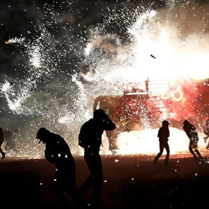 People enjoy fireworks exploding from a traditional bull known as Torito during the