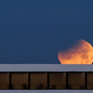 People on a ferry watch the Super Blue Blood Moon as it sets during a partial lunar