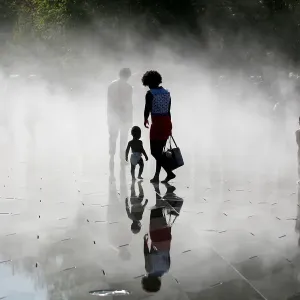 People gather near fountains of water as they cool off at the Miroir d Eau People gather near fountains of water as they cool off at the Miroir d Eau