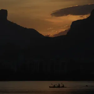 People paddle their canoe at Rodrigo de Freitas Lagoon as the sun sets in Rio de Janeiro People paddle their canoe at Rodrigo de Freitas Lagoon as the sun sets in Rio de Janeiro