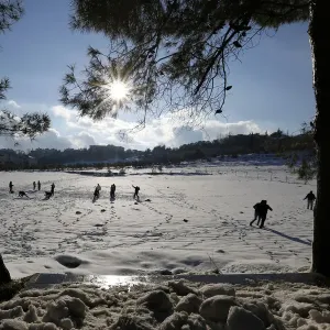 People play with snow after a heavy snowstorm in Amman