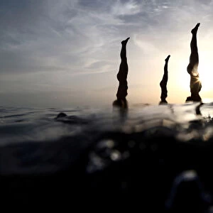 People practise standup paddleboard yoga, or SUP yoga, on the Adriatic coast in Verudela