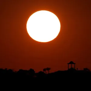 People are silhouetted against the setting sun at El Mirador de la Alemana in Malaga People are silhouetted against the setting sun at El Mirador de la Alemana in Malaga