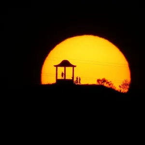 People are silhouetted against the setting sun at El Mirador de la Alemana in Malaga People are silhouetted against the setting sun at El Mirador de la Alemana in Malaga