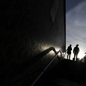 Two people stand at the top of a flight of steps that lead on to London Bridge, in London