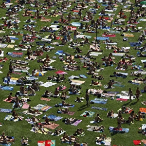 People sunbath on a field at a public swimming pool in Prague on a hot day