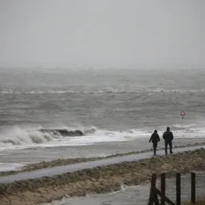 People walk on a beach at the North Sea in Cuxhaven People walk on a beach at the North Sea in Cuxhaven