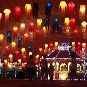 People walk past lanterns on Vesak day in Colombo