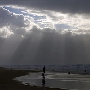 A person stands on the shores of the Mediterranean Sea on a stormy day at Nitzanim beach