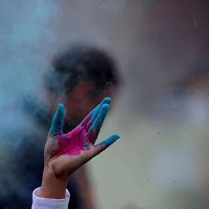 A person throws colored powder during a Holi festival party organized by Jai Jai Hooray