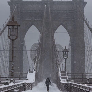 A person walks over the Brooklyn Bridge during winter storm Niko in New York City