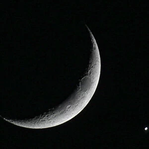 The planet Venus is seen after being eclipsed by the crescent moon, as seen from Amman