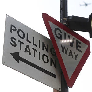 A polling station sign is attached to a lamp post in central London