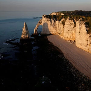 The Porte d Aval, a famous arch of the Etretats cliffs, during sunset, in Etretat