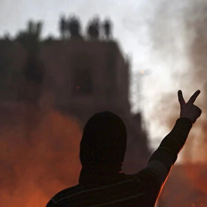 Protester opposing Egyptian President Mursi gestures at riot police during clashes in