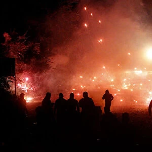 Protesters throw firecrackers during violent overnight protests against the opening of a