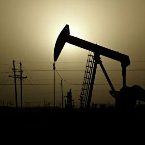 A pump jack operates at sunset in Midland