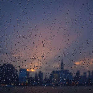Rain is seen on a window of a ferry boat as it passes midtown Manhattan and the Empire