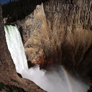 A rainbow of light is seen at the base of Yellowstone River Lower Falls in Yellowstone