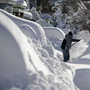 A resident shovels snow away from the entrance to his home in Union City