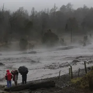 Residents watch as steam rises from the Nilhue River, fed by unusually warm water Residents watch as steam rises from the Nilhue River, fed by unusually warm water