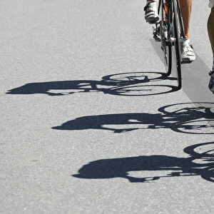 Riders shadows are projected on the road during the fourth stage of the Tour de Suisse
