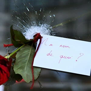 A rose placed in a bullet hole in a restaurant window the day after a series of deadly