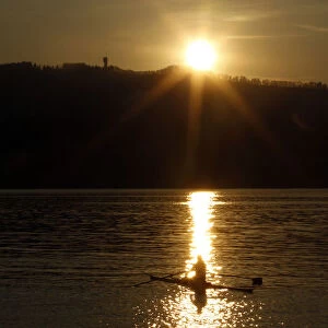 A rower is seen during sunset on Lake Zurich on a mild and sunny spring day near Kuesnacht