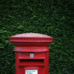 A Royal Mail post box stands on a street corner in Manchester
