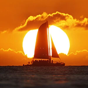 A sail boat passes in front of the sun as the last rays of sunlight of 2011 hit the