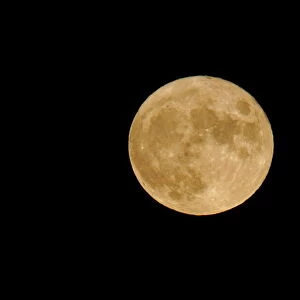 A seasonal full moon, known as the "blue moon", rises over the sky of I Faraglioni di