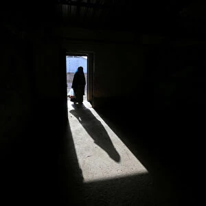 The shadow of a displaced old woman is seen in Hassan Sham camp, east of Mosul