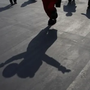 A shadow of Mickey Mouse is cast as the Disney character waves to visitors at Tokyo