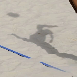 The shadow of a volleyball player is pictured as she hits the ball