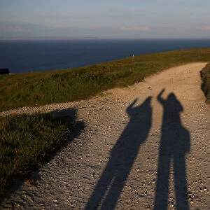 The shadows of Reuters photographer Phil Noble and journalist Mari Saito are seen