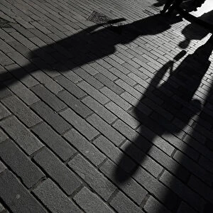 The shadows of workers are seen in the City of London financial district, London, Britain