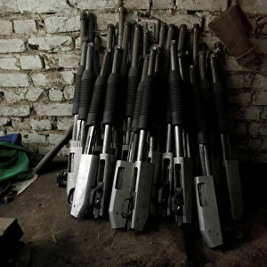 Shotguns being manufactured rest on a wall at the Peshawar Arms Company in Peshawar
