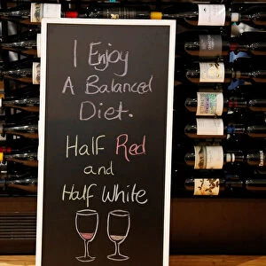 A sign is seen in front of bottles of wine being sold at a retail store at Sydney