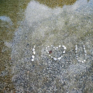 A sign made from stones is pictured in the Idrijca river in Idrijska Bela