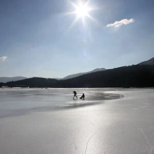 Skater drags sledge on the frozen lake Cerknica