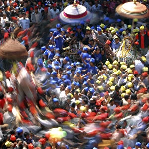 A slow motion picture of devotees carrying chariots as they participate in the Chariot